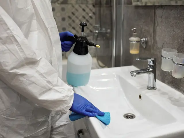 A person cleaning a bathroom basin