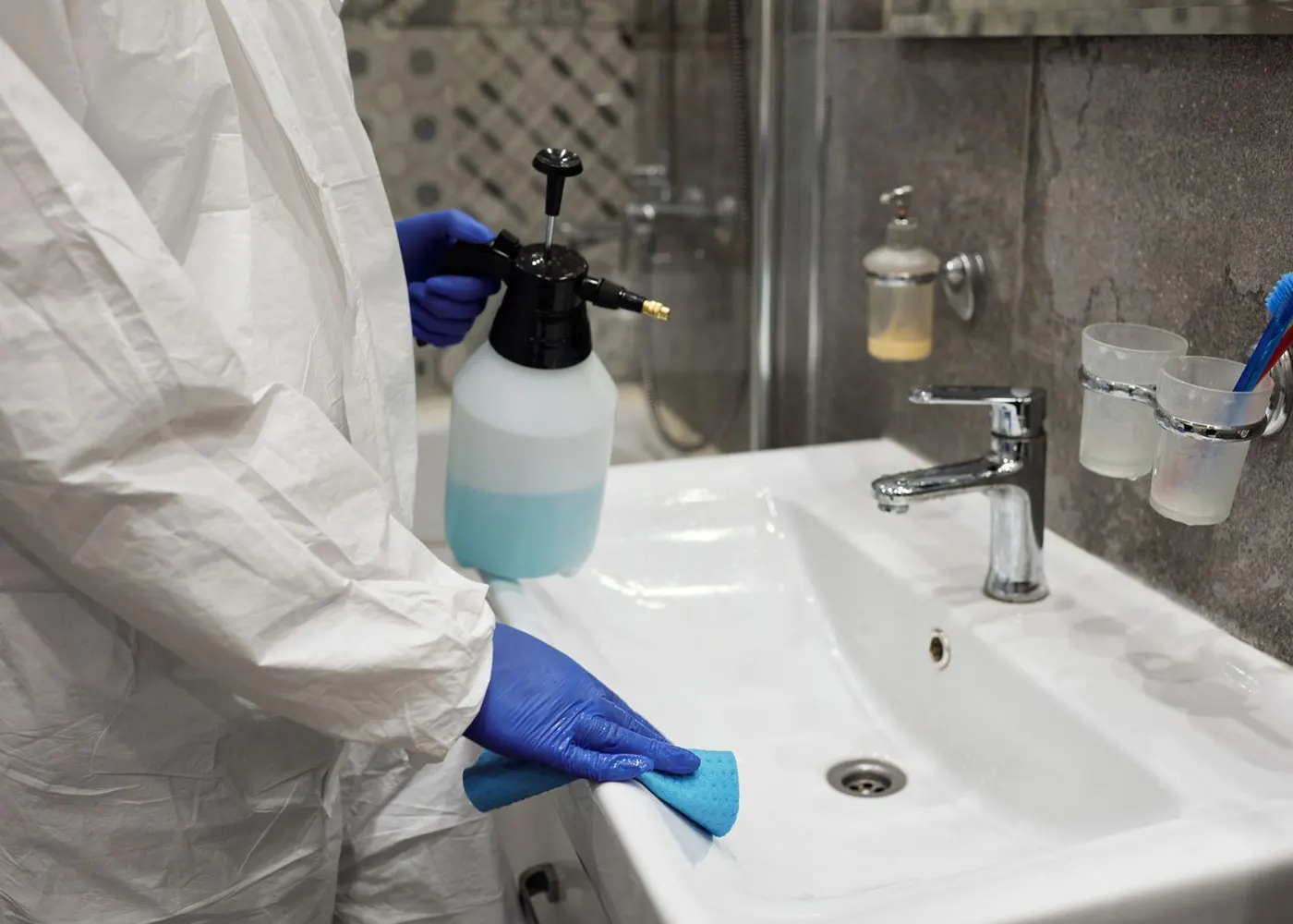 A person cleaning a bathroom basin