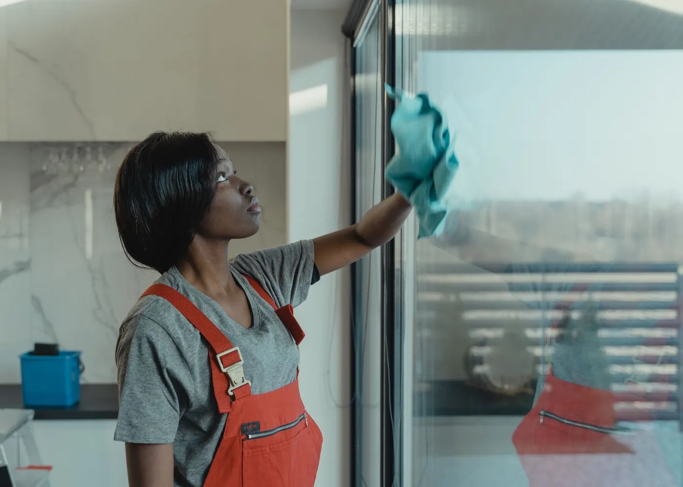 A cleaner wiping a glass window