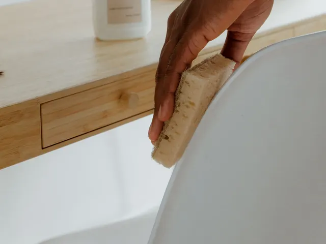 A person wiping a chair beside an office desk