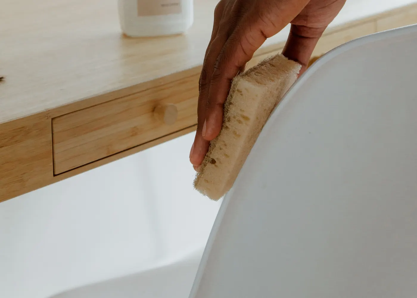 A person wiping a chair beside an office desk